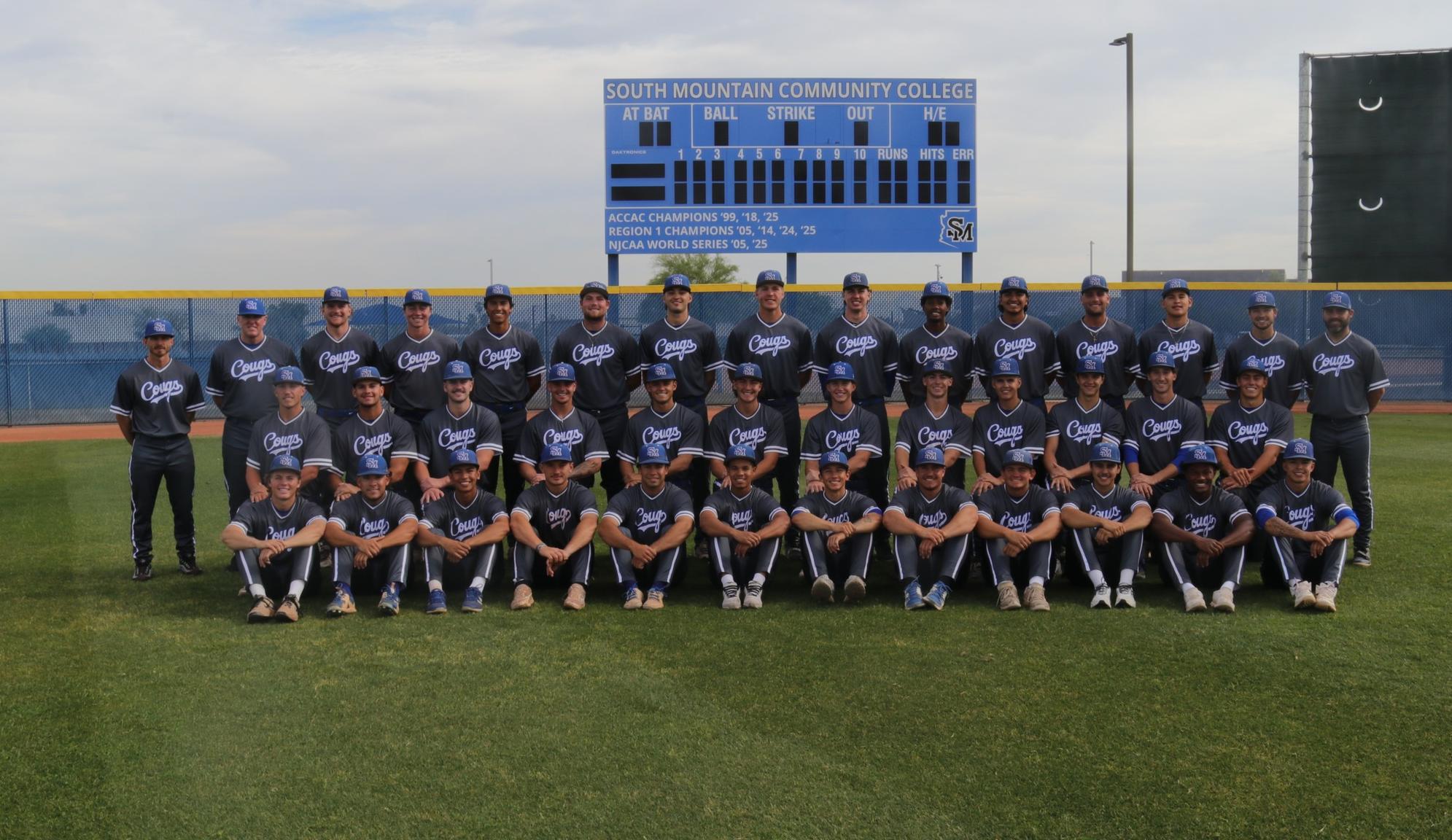 Photo: South Mountain Community College baseball team poses for its 2026 team photo on the field in front of the outfield scoreboard, with players and coaches arranged in three rows on the grass at Cougar Field.
