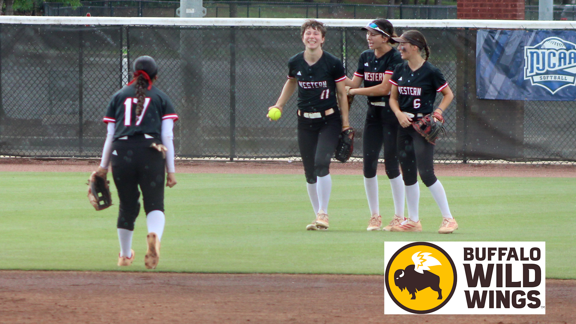 Photo: Arizona Western College softball players celebrate together in the outfield during an NJCAA Softball Championship game as a teammate jogs in from the infield carrying her glove.